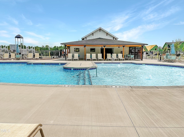 view of swimming pool with pool water feature and a patio