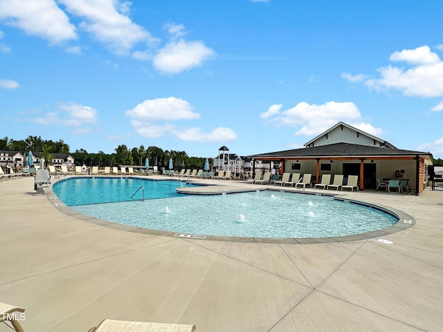 view of swimming pool with pool water feature and a patio area