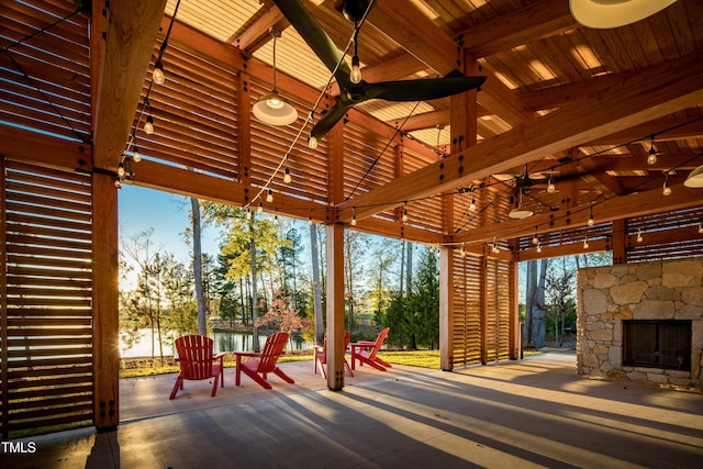 view of patio / terrace with an outdoor stone fireplace, ceiling fan, and a gazebo