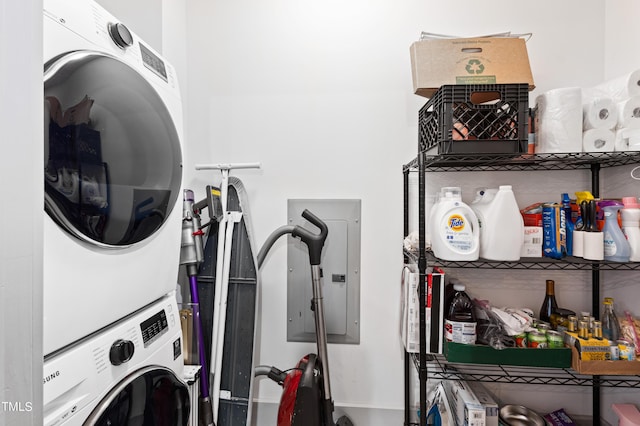 laundry area with electric panel and stacked washing maching and dryer