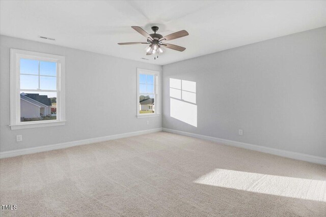 spare room with ceiling fan and light carpet