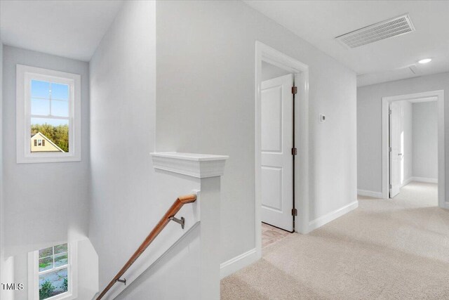 hallway featuring light colored carpet