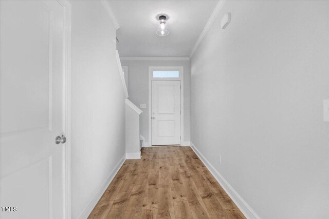 corridor featuring crown molding and light hardwood / wood-style flooring