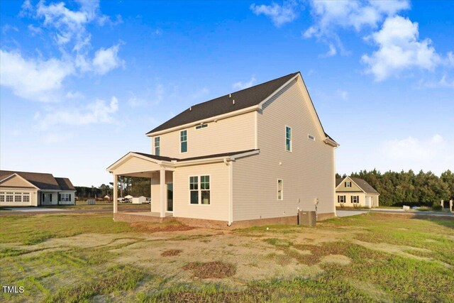 back of house featuring cooling unit, a yard, and a patio area