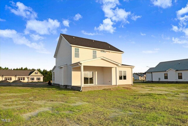 back of property featuring a lawn and a patio area