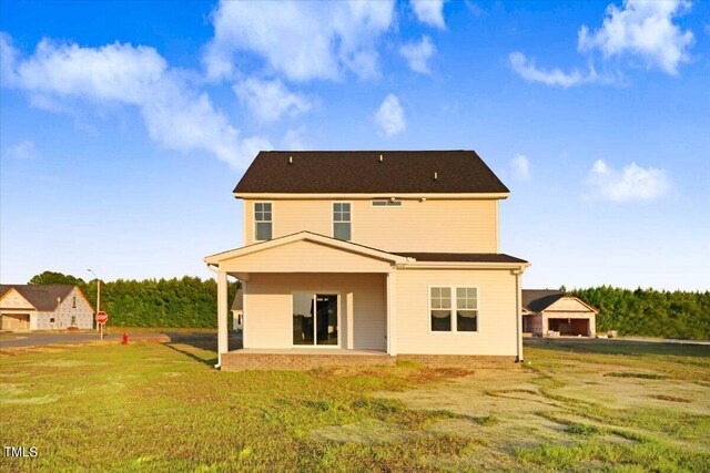 rear view of property with a patio and a lawn