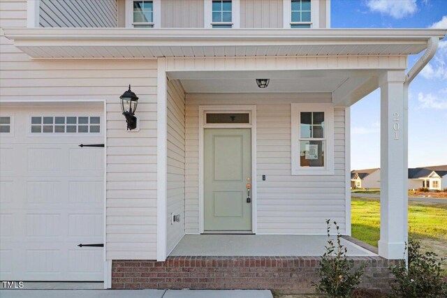 entrance to property featuring a garage and covered porch