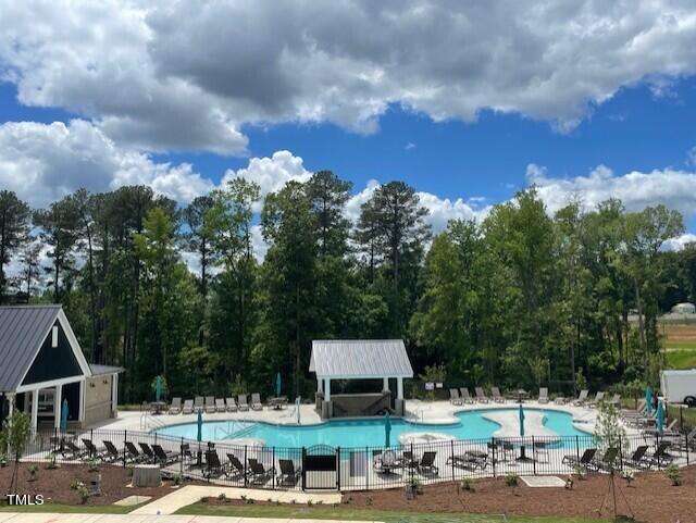 pool with a patio, an outdoor structure, and fence