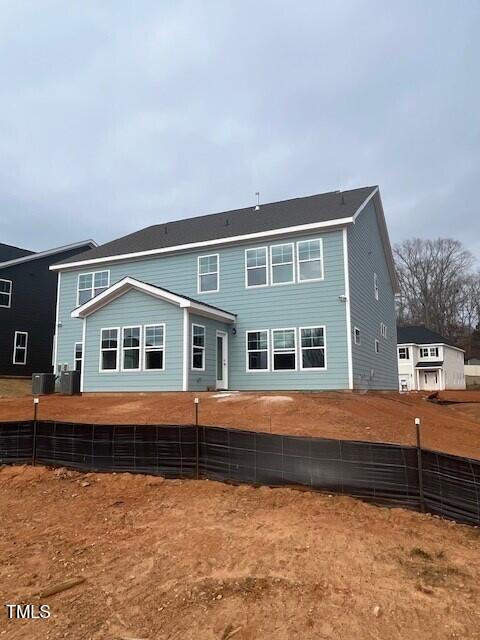 back of house with central AC unit