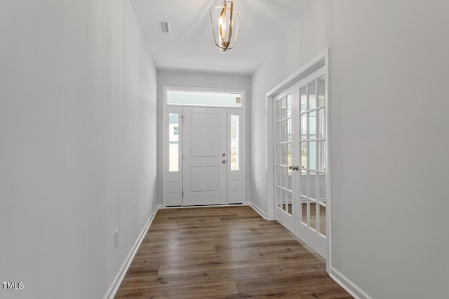 foyer featuring visible vents, baseboards, and wood finished floors