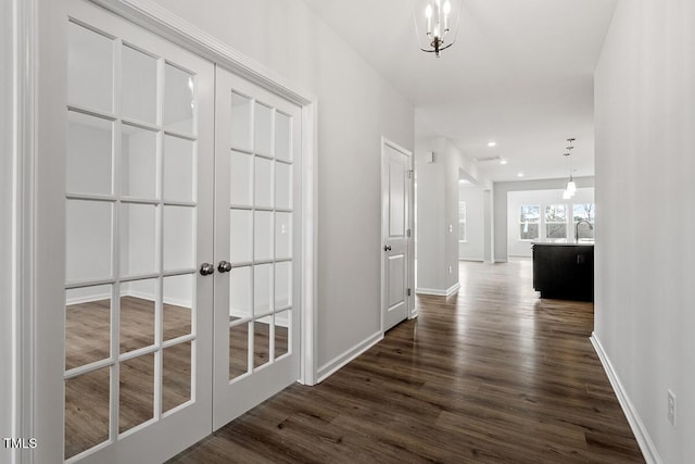 hall featuring dark wood-style floors, recessed lighting, a sink, and baseboards