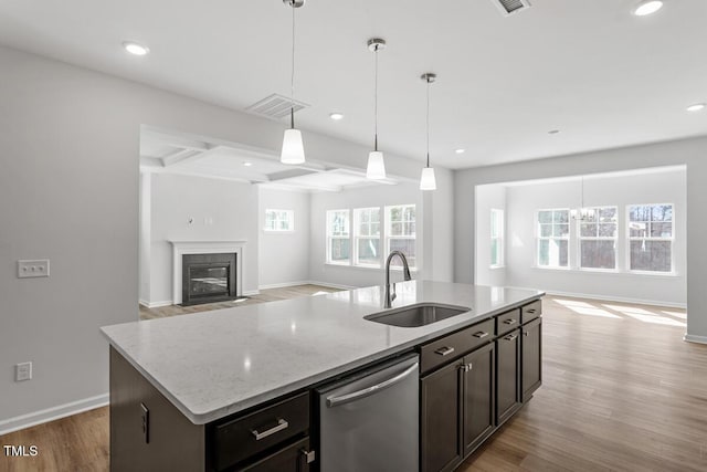 kitchen with a sink, light wood-style floors, open floor plan, and stainless steel dishwasher