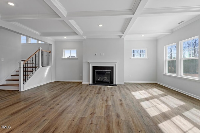 unfurnished living room featuring a fireplace with flush hearth, stairway, wood finished floors, and baseboards