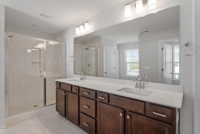 bathroom featuring double vanity, a sink, visible vents, and a shower stall