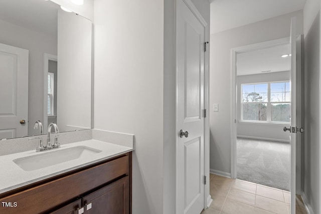 bathroom with tile patterned flooring, baseboards, and vanity