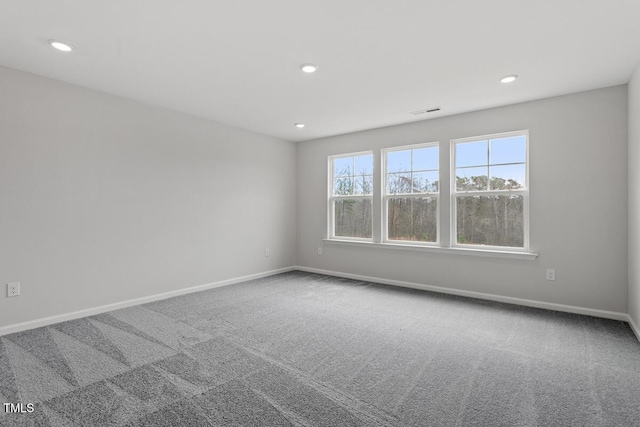 empty room with carpet, visible vents, baseboards, and recessed lighting