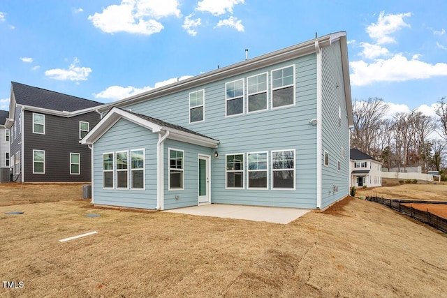 back of house with a patio and a lawn