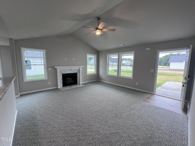 unfurnished living room with carpet, baseboards, lofted ceiling, and ceiling fan