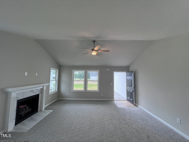unfurnished living room with carpet floors, ceiling fan, vaulted ceiling, and a fireplace