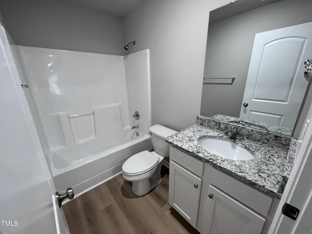 full bathroom with toilet, wood finished floors, vanity, and washtub / shower combination