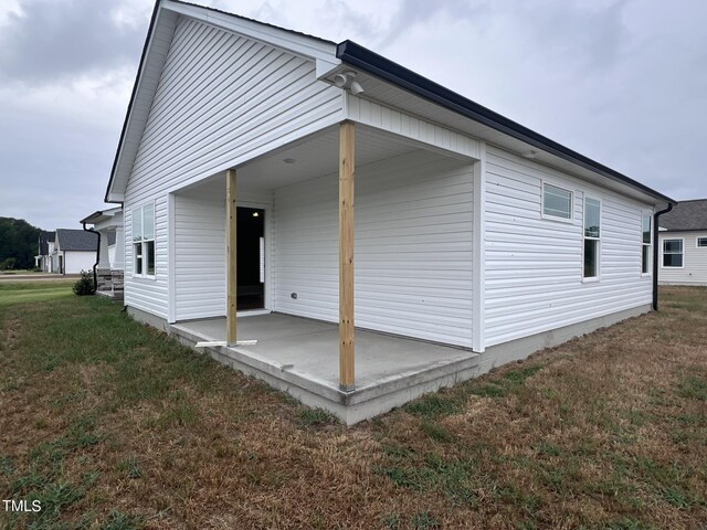 rear view of property featuring a patio and a yard