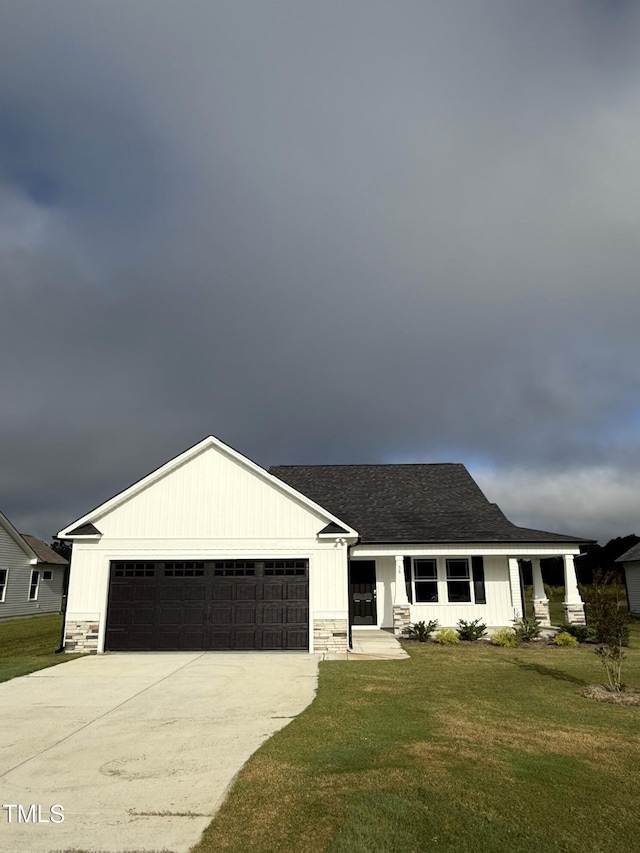 ranch-style house with a garage, driveway, stone siding, and a front lawn