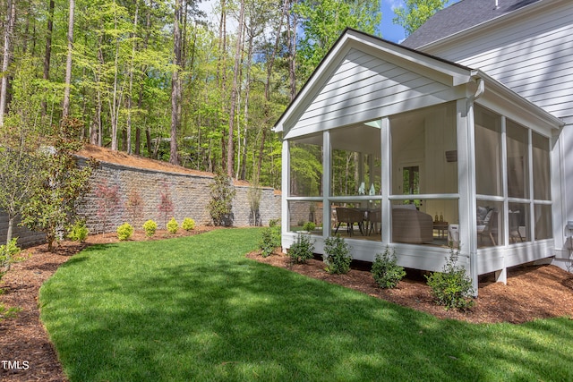 view of property exterior with a sunroom and a lawn