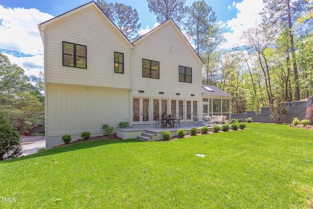 rear view of house with a yard, a sunroom, and a patio