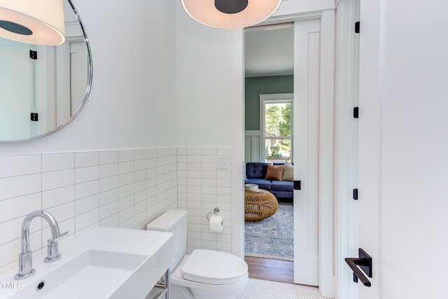 bathroom with sink, tile walls, toilet, and tile patterned flooring