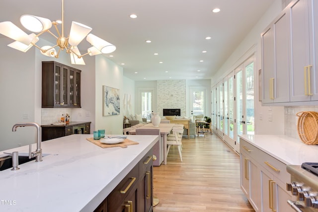 kitchen with backsplash, pendant lighting, and dark brown cabinets