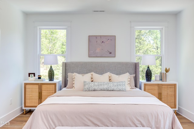 bedroom featuring multiple windows and hardwood / wood-style flooring