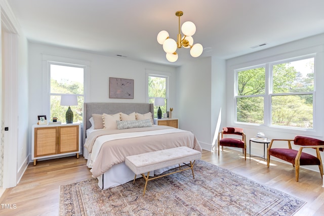 bedroom with a chandelier and light hardwood / wood-style flooring