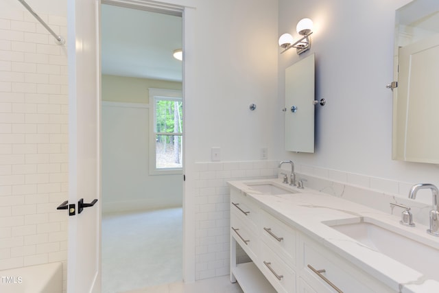 bathroom with tiled shower / bath combo and vanity