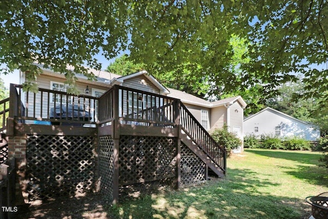 back of property featuring a deck and a lawn