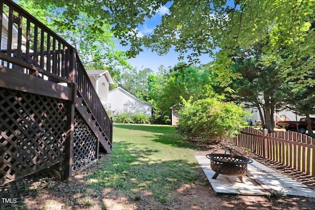 view of yard with a deck and an outdoor fire pit