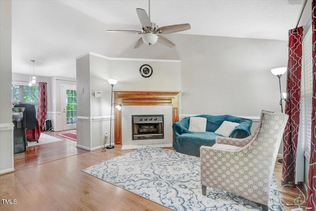 living room with a fireplace, light hardwood / wood-style flooring, ceiling fan, and lofted ceiling