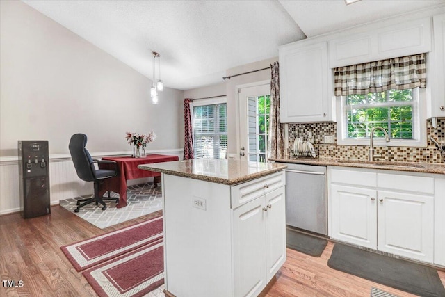 kitchen featuring white cabinets, dishwasher, light wood-type flooring, and sink