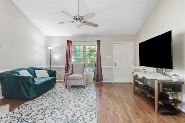 living room featuring ceiling fan, light wood-type flooring, and vaulted ceiling