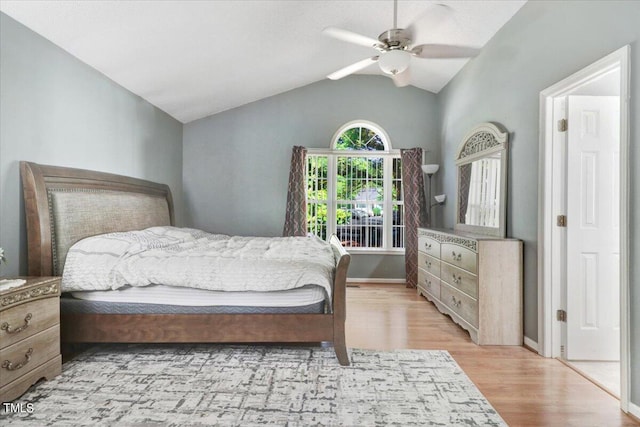 bedroom with light hardwood / wood-style floors, vaulted ceiling, and ceiling fan