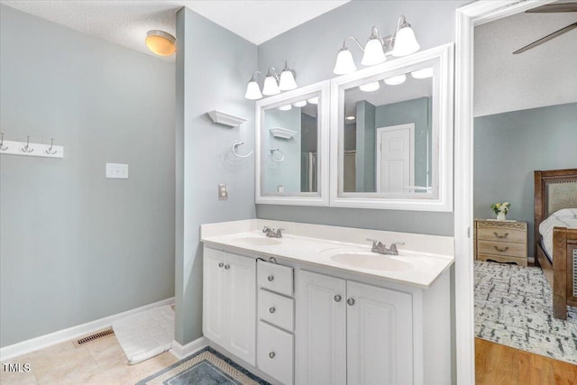 bathroom with vanity, ceiling fan, and a textured ceiling