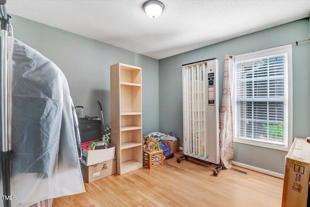 bedroom with hardwood / wood-style floors and a textured ceiling