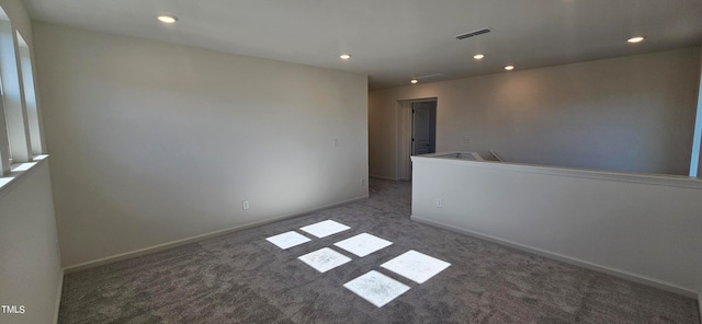 unfurnished room featuring dark colored carpet