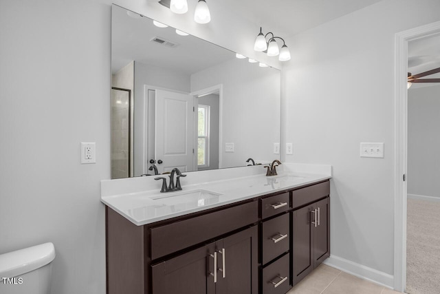 bathroom featuring toilet, vanity, a shower with door, ceiling fan, and tile patterned flooring