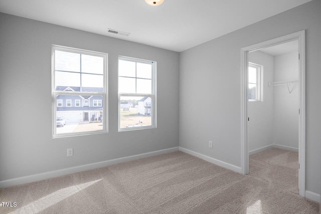 empty room featuring light colored carpet and a wealth of natural light