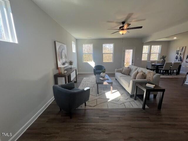 living room featuring plenty of natural light, dark wood-type flooring, and ceiling fan