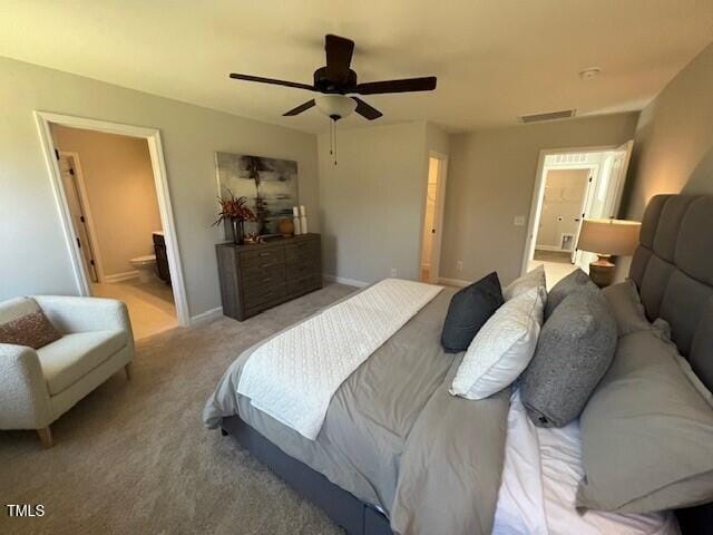 bedroom featuring light colored carpet, ceiling fan, and ensuite bathroom