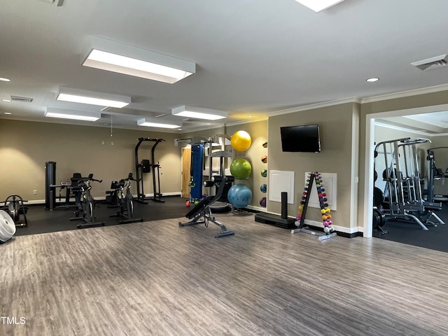 gym featuring dark wood-type flooring and ornamental molding