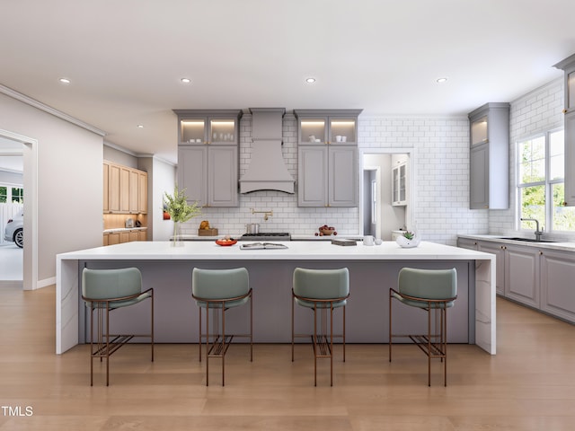 kitchen with a spacious island, custom range hood, and gray cabinetry