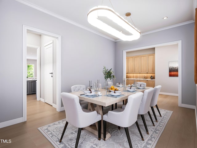 dining room with light hardwood / wood-style floors and crown molding