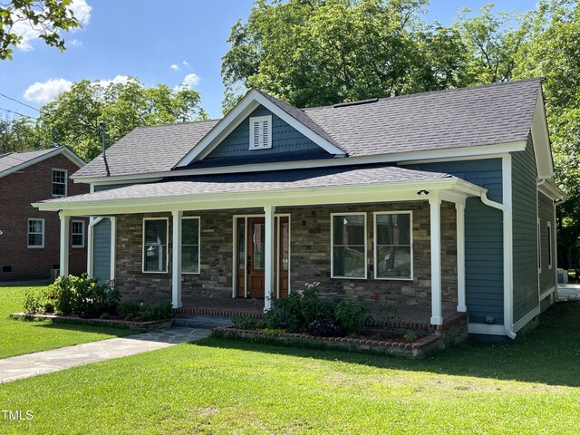 223 E Nash St, Spring Hope, NC 27882 - view of front facade with a shingled roof, stone siding, a front lawn, and covered porch